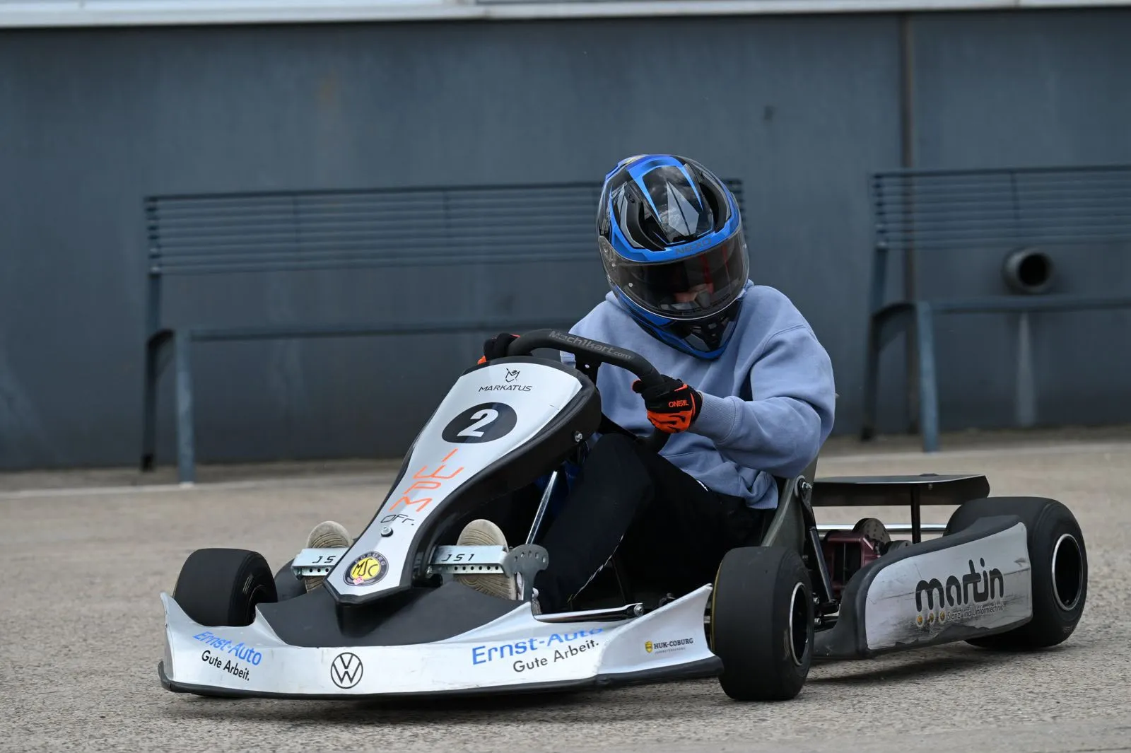 Nachwuchsfahrer mit blauem Helm im Kart mit Startnummer 2
