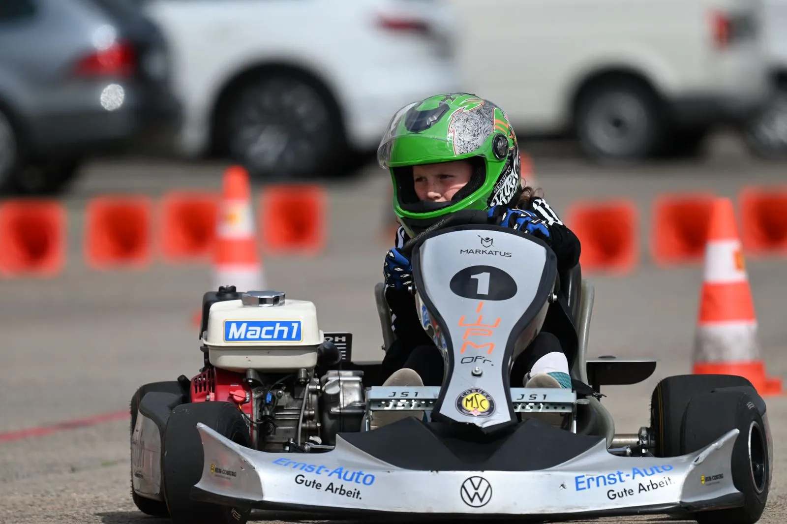 Nachwuchsfahrer mit grünem Helm im MSC-Kart mit Startnummer 1 zwischen Pylonen